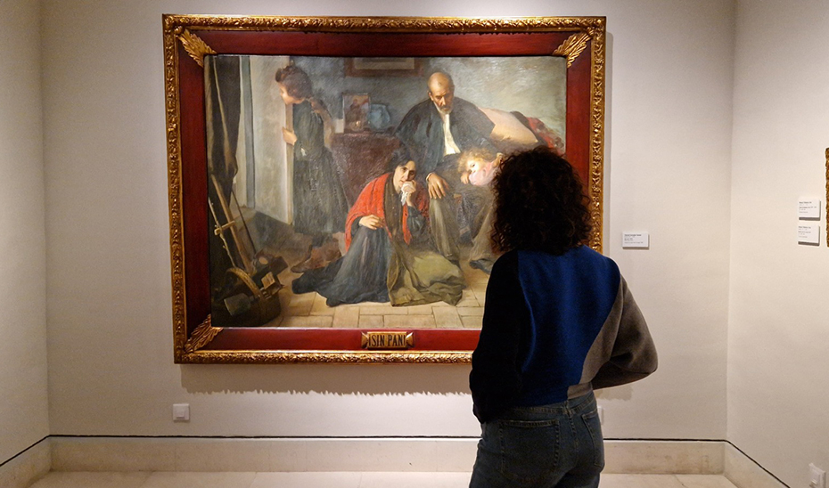 Una visitante ante el óleo 'Sin pan', de González Santos, que forma parte de la muestra 'Tres artistas andaluces conmemorados' en el Bellas Artes de Sevilla.